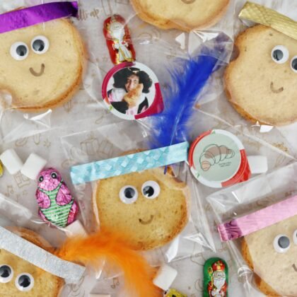 Pietenbeschuitjes, beschuitjes per stuk verpakt met washitape en een veer als Piet in een beschuitbox